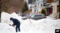 A person removes snow from the front of his driveway a few days after a winter storm rolled through western New York, Dec. 29, 2022, in Buffalo N.Y. 