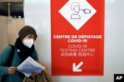 A passenger coming from China leaves a COVID-19 testing area set at the Roissy Charles de Gaulle airport, north of Paris, Jan. 1, 2023.