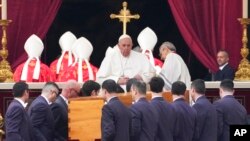 Pope Francis sits as the coffin of late Pope Emeritus Benedict XVI is carried for a funeral Mass at the Vatican, Jan. 5, 2023.
