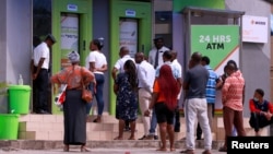 FILE - People queue at a bank in Abuja, Nigeria, March 30, 2020.