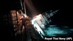 The HTMS Sukhothai corvette warship lists off the coast of Prachuap Khiri Khan province, Thailand, Dec. 18, 2022. The Thai navy ship sunk in the Gulf of Thailand and ships and helicopters were working to rescue sailors from the water.