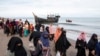 Ethnic Rohingya people walk to a temporary shelter after they landed on their wooden boat in North Aceh, Indonesia, Nov. 16, 2022.