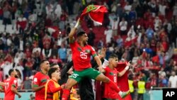 Morocco's Yahia Attiyat Allah (25) celebrates with teammates after the World Cup quarterfinal soccer match against Portugal at Al Thumama Stadium in Doha, Qatar, Dec. 10, 2022.