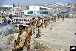 Soldiers stand guard after clearing a roadblock to the airport, created by supporters of ousted Peruvian President Pedro Castillo in Arequipa, Peru, Dec. 14, 2022.