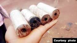 A refugee holding remains of teargas police used to stop the violence at the camp. (Courtesy picture by refugees who witnessed the violence)