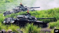 Tank-tank Pasukan Bela Diri Darat Jepang menembakkan peluru saat menggelar latihan militer di kaki Gunung Fuji di Jepang tengah.(Foto: AP/Katsumi Kasahara)