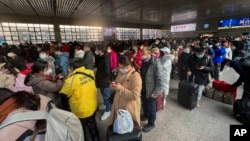 អ្នក​ដំណើរ​ពាក់មា់ស​នៅ​ស្ថានីយ​រថភ្លើង​ West Railway Station ក្នុងទីក្រុង​ប៉េកាំង ប្រទេស​ចិន ថ្ងៃទី ៦ ខែមករា ឆ្នាំ២០២៣។ 