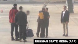 აშშ-ს და რუსეთს შორის პატიმრების გაცვლის მომენტი, როცა ამერიკელი ბრიტნი გრაინერი და რუსი ვიქტორ ბუტი გაცვალეს. აბუ-დაბის აეროპორტი, არაბთა გაერთიანებული საამიროები. 8 დეკემბერი, 2022 წ. AFP/ RUSSIAN STATE MEDIA