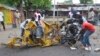 People inspect a damaged tricycle at the site of a bomb explosion, caused by a female suicide bomber in a market in Maiduguri, Nigeria, July 31, 2015. 