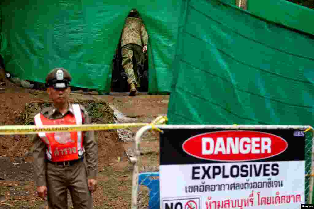 An Australian soldier enters the Tham Luang cave complex, where 12 schoolboys and their soccer coach are trapped inside a flooded cave, after Thailand&#39;s government instructed members of the media to move out urgently, July 8, 2018.
