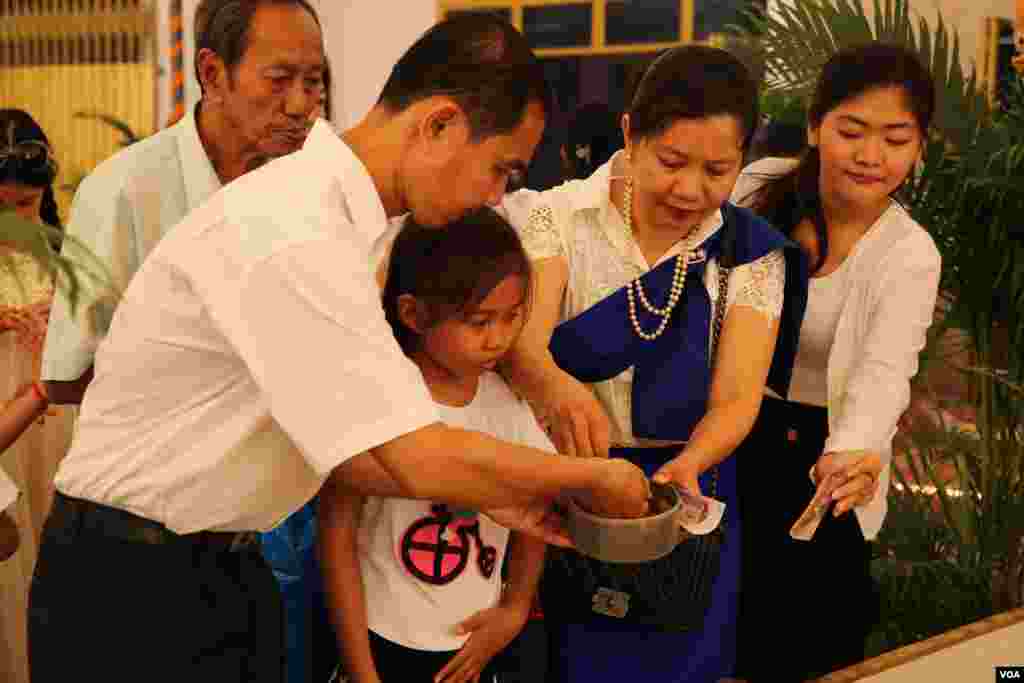 ពុទ្ធសាសនិក​មួយ​គ្រួសារ​ពូន​ភ្នំ​ខ្សាច់​នៅ​ថ្ងៃបុណ្យ​ភ្ជុំបិណ្ឌ​ ក្នុង​វត្ត​មួយ​កណ្តាល​រាជធានី​ភ្នំពេញ កាលពី​ថ្ងៃទី១ ខែតុលា ឆ្នាំ២០១៦។ (ហ៊ាន សុជាតា/VOA)