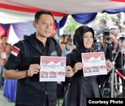 Calon gubernur Jakarta Agus Harimurti Yudhoyono bersama istri memberikan suara di sebuah TPS (15/2). (Courtesy: Anung Anindito)
