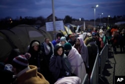 Refugees fleeing Russia's invasion of Ukraine queue at the Medyka border crossing, Poland, March 10, 2022. (AP Photo/Daniel Cole, File)