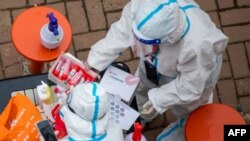 Medical workers prepare to conduct nucleic acid tests for COVID-19 for residents in China's northeastern Jilin province on March 12, 2022.