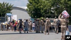 People walk to the closed border bridge to wait and be let through and return to Haiti, from Dajabon, Dominican Republic, Sept. 15, 2023. 
