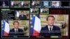 FILE - This photograph taken March 12, 2020, shows screens displaying France's President Emmanuel Macron giving a speech, at a France 24 TV studio, in Issy-Les-Moulineaux, near Paris.