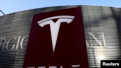 Logo produsen kendaraan listrik Tesla di dekat kompleks perbelanjaan di Beijing, China, 5 Januari 2021. (Foto: REUTERS/Tingshu Wang)