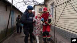 Fotograf Associated Pressa Evgenij Maloletka pomaže bolničaru da preveze ženu povrijeđenu tokom granatiranja u Mariupolju, na istoku Ukrajine, 2. marta 2022.