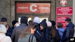 Moun fe la ke nan biwo paspo vil Vasovi a nan Poloy, Lendi, 14 Mas 2022. 