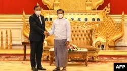 លោក ប្រាក់ សុខុន (ឆ្វេង) រដ្ឋមន្ត្រី​ការបរទេស​កម្ពុជា និង​ជា​ប្រេសិត​​របស់​ប្រធាន​អាស៊ាន ចាប់​ដៃ​គ្នា​ជាមួយ​នឹង​ប្រមុខ​រដ្ឋាភិបាល​យោធា​មីយ៉ាន់ម៉ា លោក​ឧត្តមសេនីយ៍ Min Aung Hlaing ទីក្រុង​ណៃពិដោ ប្រទេស​មីយ៉ាន់ម៉ា ថ្ងៃទី២១ ខែមីនា ឆ្នាំ២០២២។ (MYANMAR MILITARY INFORMATION TEAM / AFP) 