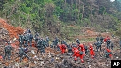 In this photo released by Xinhua News Agency, rescue workers search for the black boxes at a plane crash site in Tengxian county, southwestern China's Guangxi Zhuang Autonomous Region, March 22, 2022.