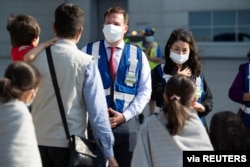 FILE - Afghan refugees are greeted after arriving in Canada, Aug. 4, 2021.