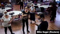 Walter Perez teaches a seniors dance class .They are able to socialize and get exercise. Picture taken March 7, 2022. (REUTERS/Mike Segar)