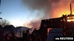 Petugas pemadam kebakaran sedang memadamkan bangunan tempat tinggal yang rusak akibat penembakan, saat invasi Rusia ke Ukraina berlanjut, di Kyiv, Ukraina, dalam gambar selebaran yang diperoleh Reuters pada 16 Maret 2022. (Foto: via Reuters)