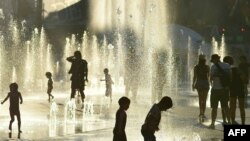 Des enfants jouent dans les fontaines d'eau de la Place des Arts à Montréal, Canada par une chaude journée d'été