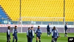 Parma's players warm up on the field moments before a Serie A soccer match between Parma and Spal was scheduled to be played, in Parma, northern Italy, March 8, 2020.