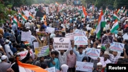 Demonstrators hold placards and flags as they attend a protest rally against a new citizenship law, in Hyderabad, India, Jan. 4, 2020. 