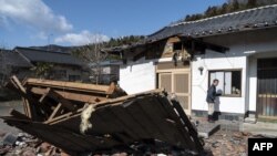 Sushi maker Akio Hanzawa walks in front of his damaged restaurant in Shiroishi, Miyagi prefecture on March 17, 2022.