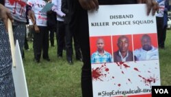 FILE - A protester holds a sign picturing human rights attorney Willie Kimani, his client Josephat Mwenda and their taxi driver Joseph Muiruri allegedly killed by police, at a rally in Nairobi, Kenya, July 4, 2016. (J. Craig/VOA)