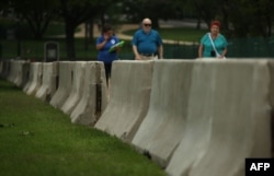 Barricades are seen as tourists pass by at the west front of the U.S. Capitol in Washington, D.C., where security has been increased for the upcoming July 4 holiday, July 2, 2015.