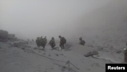 Japan Self-Defense Force (JSDF) soldiers conduct rescue operations near the peak of Mount Ontake, which erupted September 27, 2014 and straddles Nagano and Gifu prefectures, central Japan, in this handout photograph released by the Joint Staff of the Defe