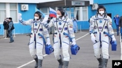 In this photo released by Roscosmos Space Agency, Russian cosmonauts, Оleg Аrtemyiv, center, Denis Мatveev, right, and Sergei Korsakov, walk to the launch pad at the Baikonur Cosmodrome, Kazakhstan, March 18, 2022. 