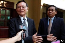 រូបឯកសារ៖ អតីតប្រធាន​គណបក្ស​សង្គ្រោះជាតិ លោក កឹម សុខា (ឆ្វេង) ថ្លែង​ទៅ​កាន់​អ្នក​សារព័ត៌មាន មុន​ពេល​លោក​ចេញ​ដំណើរ​ពី​ផ្ទះ​ទៅ​កាន់​សាលា​រាជធានី​ភ្នំពេញ​ដើម្បី​ចូលរួម​សវនាកា​រ​កាត់ក្ដី​លោក ថ្ងៃទី១៩ ខែមករា ឆ្នាំ២០២២។ (AP)