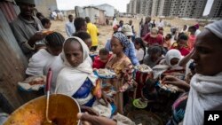 FILE - People queue to receive food donated by local residents at a reception center for the internally displaced, in Mekele, in Ethiopia's Tigray region, May 9, 2021.