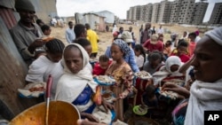 FILE - Tigrayans queue to receive food donated by local residents at a reception center for the internally displaced, in Mekele, in Ethiopia's Tigray region, May 9, 2021. 