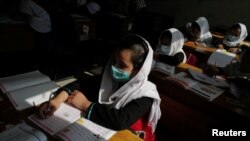 FILE - A 4th grade primary school student attends a class in Kabul, Afghanistan, October 26, 2021.