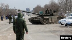 Solda pwo La Risi chita nan yon tank pandan yon konfli an Ikren ak La Risi andeyo vil potye Mariupol, nan sid Ikren, 20 Mas 2022. 