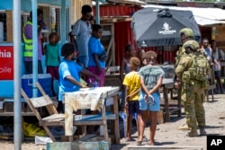 FILE - Australian Army soldiers talk with local citizens during a community engagement patrol through Honiara, Solomon Islands, Nov. 27, 2021. A leaked document indicates that China could boost its military presence in the Solomon Islands. (Cpl. Brandon Grey/Department of Defence via AP, File)