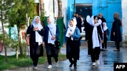 Girls arrive at their school in Kabul, Afghanistan, on March 23, 2022. But the Taliban said that high schools will not reopen for girls until a plan was drawn up to follow Islamic law and Afghan culture. (Photo by Ahmad SAHEL ARMAN / AFP)