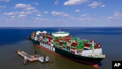 Awak kapal mengeruk lokasi di dekat kapal kontainer Ever Forward dalam upaya membebaskannya setelah kandas di lepas pantai dekat Pasadena, Maryland., 21 Maret 2022.