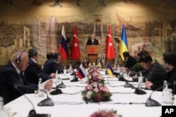 Presiden Turki Recep Tayyip Erdogan, tengah, memberikan pidato untuk menyambut delegasi Rusia, kiri, dan Ukraina menjelang pembicaraan mereka, di Istanbul, Turki, Selasa, 29 Maret 2022. (Foto: via AP)