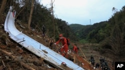 In this photo released by Xinhua News Agency, Emergency workers use sniffer dogs to search through debris at the China Eastern flight crash site in Tengxian county in southern China's Guangxi Zhuang Autonomous Region, March 22, 2022.