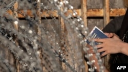 FILE - Asylum seekers from Ukraine wait for US border authorities to allow them in on the Mexican side of the San Ysidro Crossing port in Tijuana, Baja California state, Mexico, on March 24, 2022.