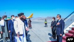 Menteri Luar Negeri Taliban Amir Khan Muttaqi (kiri) menyambut kedatangan Menteri Luar Negeri China Wang Yi (kanan) ketika Wang tiba di Bandara Kabul, pada 24 Maret 2022. (Foto: Taliban Foreign Ministry/AFP)