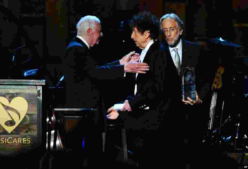 Mantan presiden AS Jimmy Carter (kiri) memberikan Bob Dylan penghargaan Tokoh Tahun dalam acara MusiCares 2015 di Los Angeles.