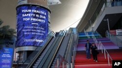 FILE - People walk out of a shopping mall devoid of the usual crowds during the coronavirus outbreak, May 26, 2020, in Las Vegas. 